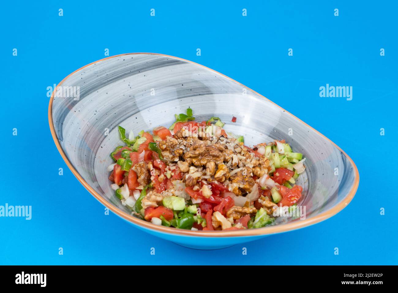 Vista di insalata di noci sparata dalla vista opposta o laterale su sfondo blu in un ambiente isolato. Foto Stock
