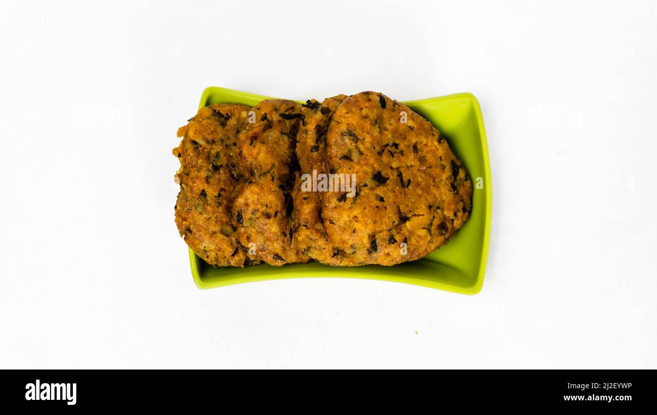 Forma del cuore Gujarati spuntini Muthiya in Green Square Bowl - cottura a vapore cibi sani, Ketchup Catsup Sauce, piatto intero isolato sfondo bianco Foto Stock