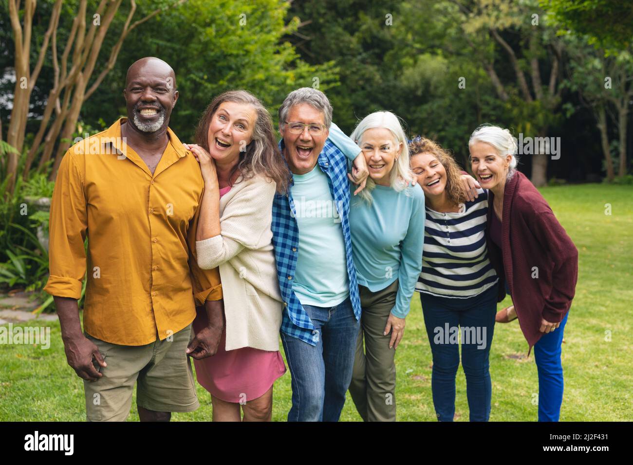 Ritratto di felice multirazziale senior maschile e femminile amici godendo in cortile Foto Stock