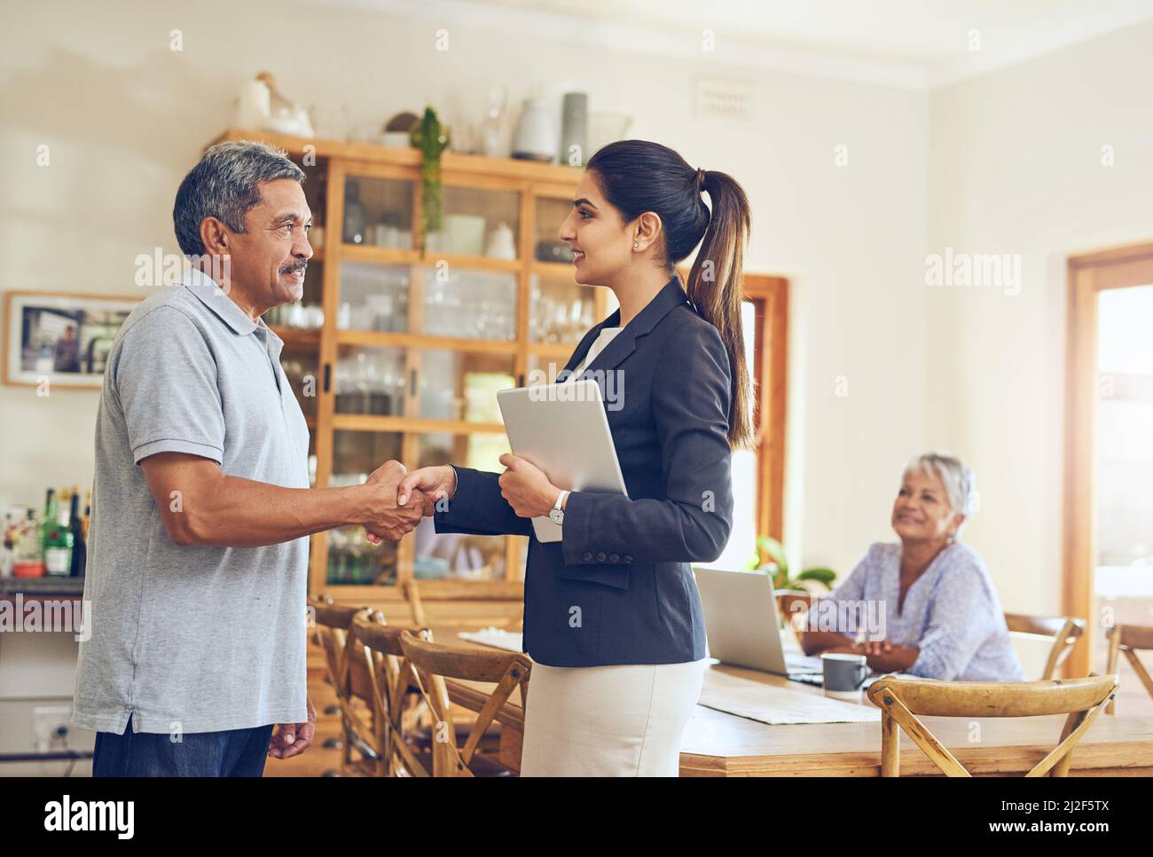 Lascia parlare di creazione di un ritiro sicuro per voi. Shot di una coppia matura riunione con il loro consulente finanziario a casa. Foto Stock