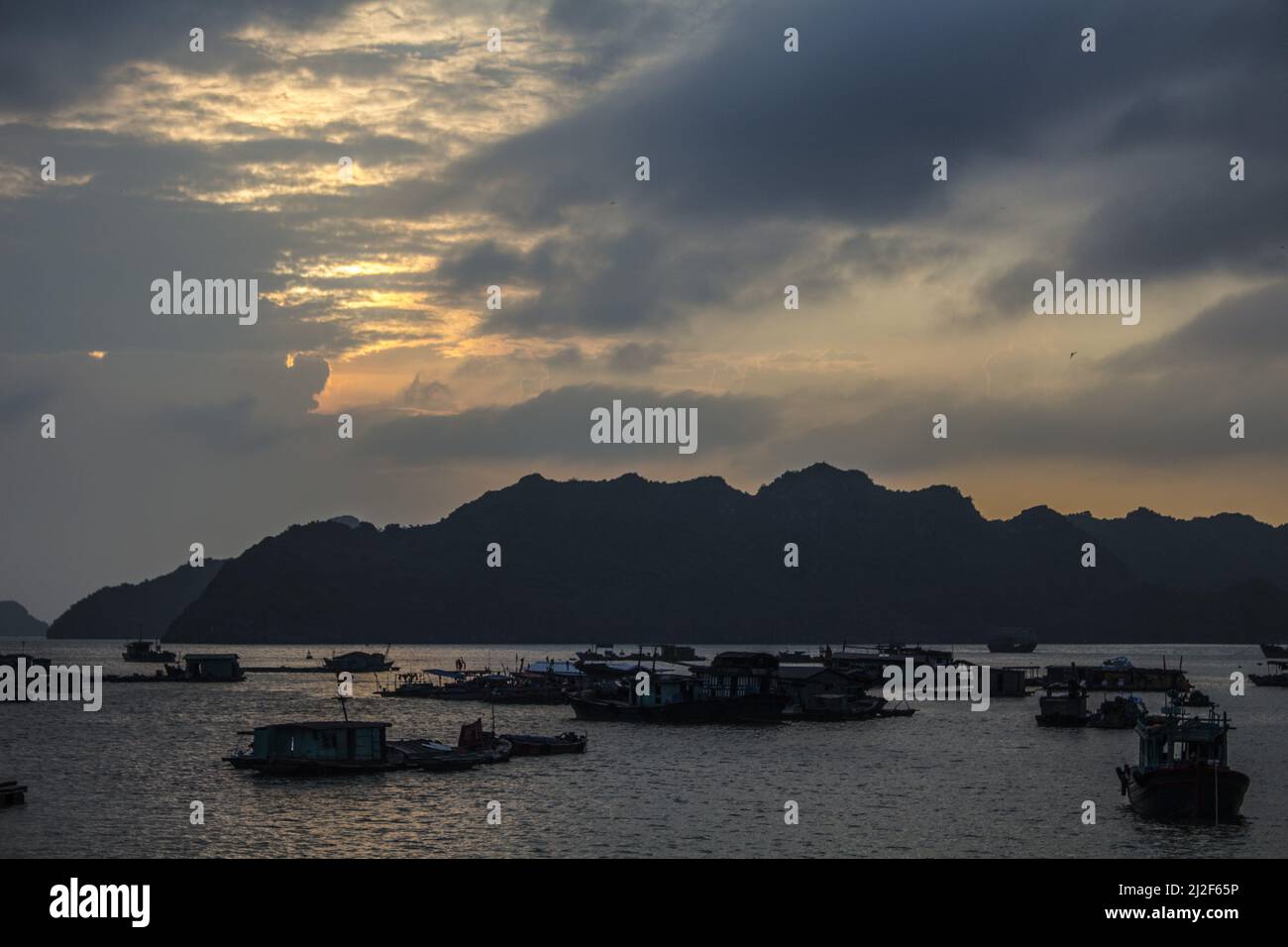 La vista delle barche contro le colline al tramonto. Vinh ha Long, Vietnam. Foto Stock