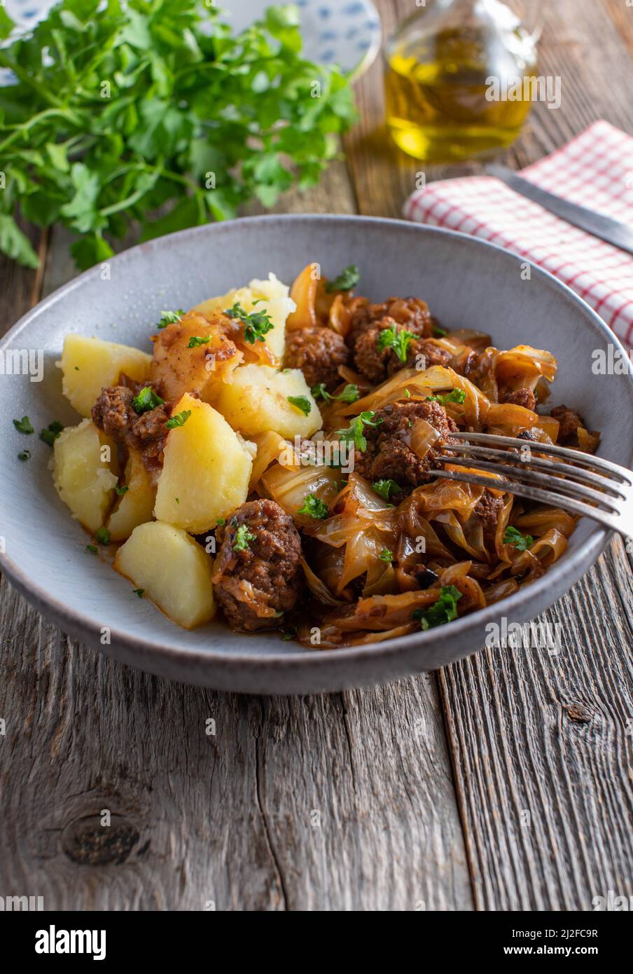 Piatto rustico con polpette, cavolo, salsa e patate. Immagine verticale con spazio di copia Foto Stock