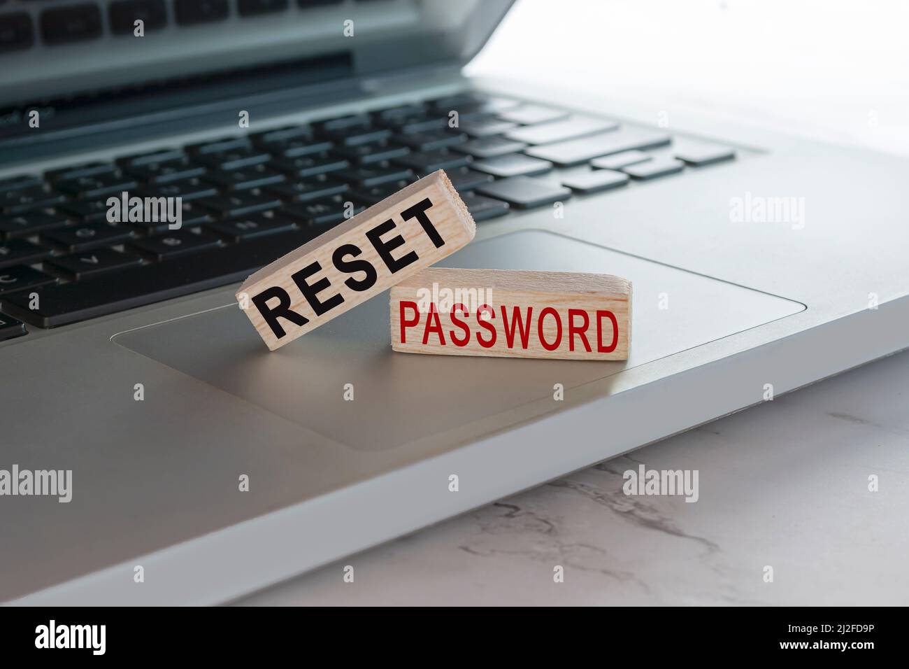 Reimpostare il testo della password sul cubo di legno posto sul portatile o sul notebook. Concetto di protezione tramite password. Foto Stock
