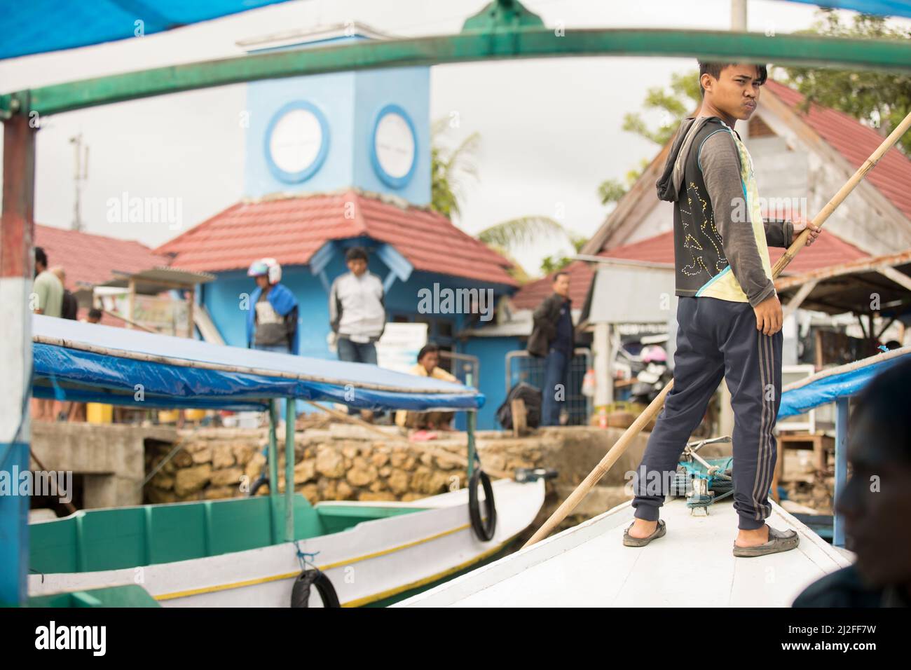 Barcaiolo che attraversa il porto e i moli nella città di Mamuju, Sulawesi, Indonesia, Asia. Foto Stock