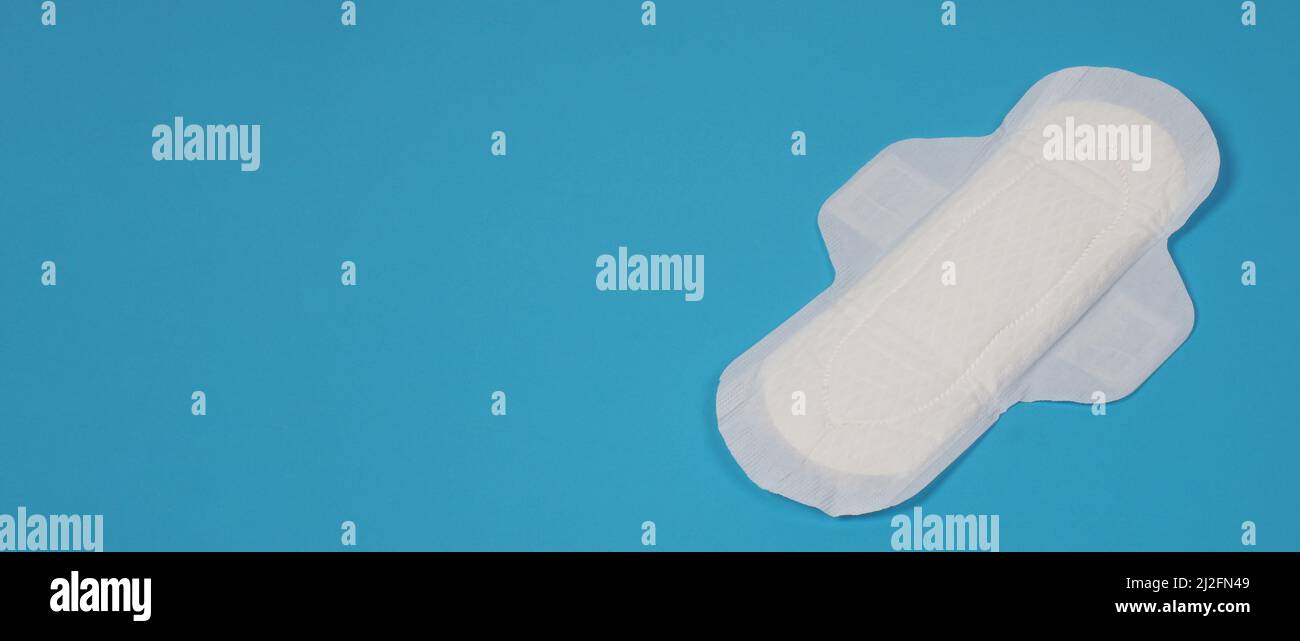 Assorbenti igienici donna su sfondo blu. Vista dall'alto. Tamponi assorbenti indossati dalle donne per assorbire il sangue mestruale. Comodi assorbenti igienici bianchi disposti Foto Stock