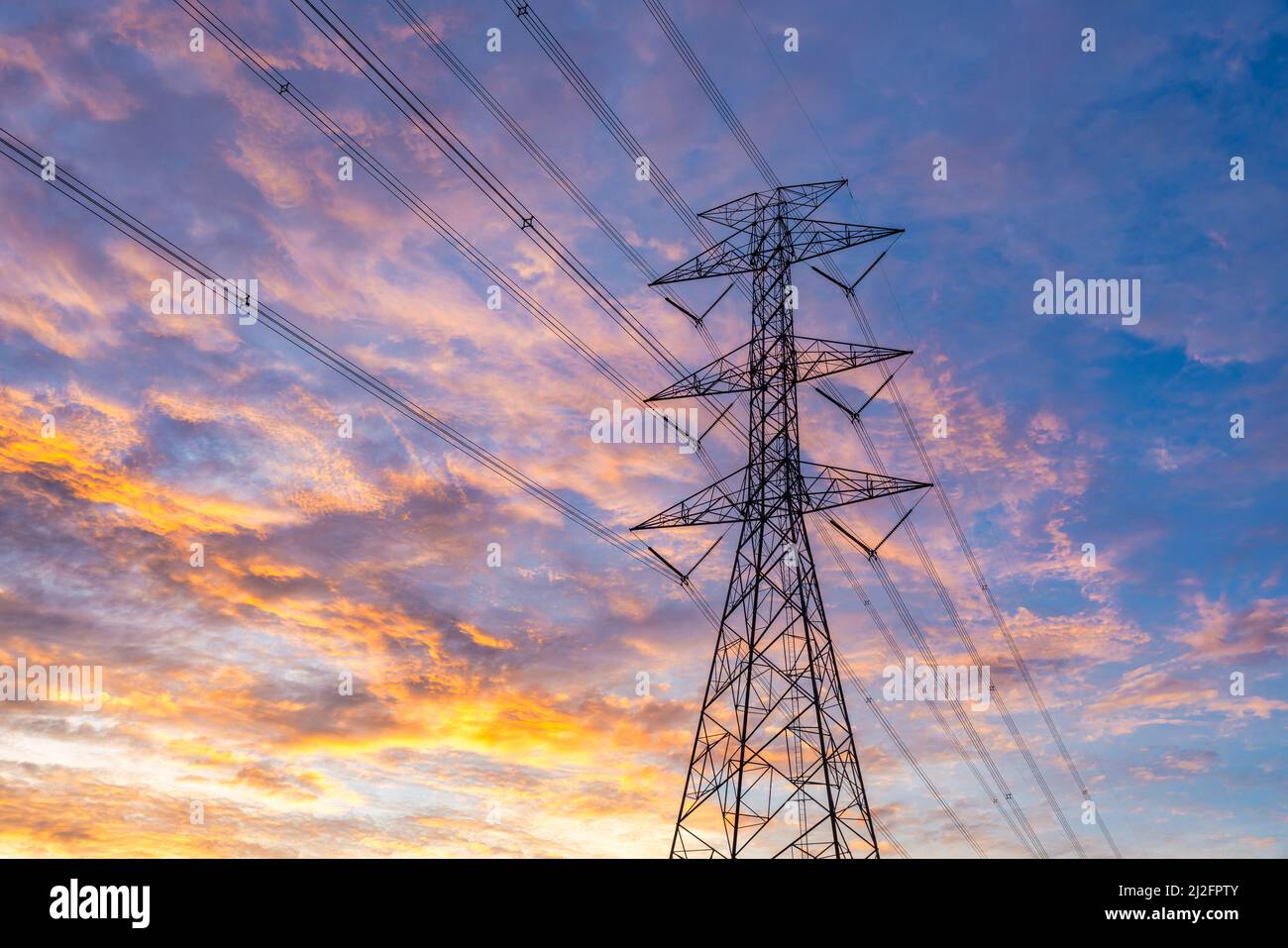 Primo piano di High Voltage Post, torre ad alta tensione cielo sfondo tramonto. Foto Stock