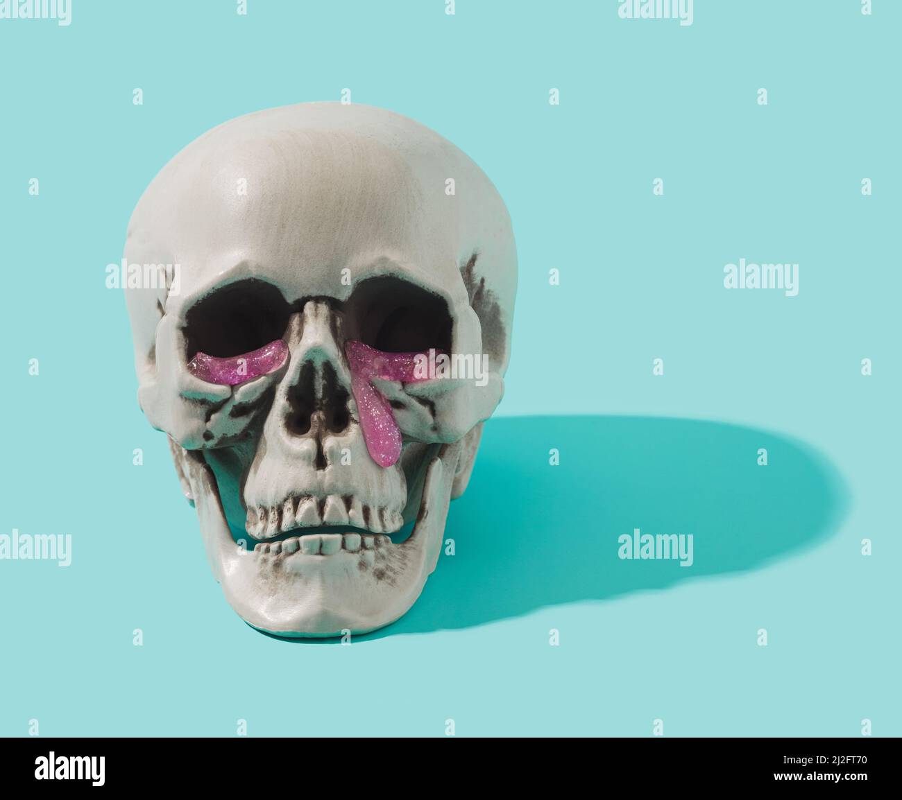 Cranio umano con lacrime di goo rosa che cadono dagli occhi. Cyber tristezza background concettuale. Foto Stock