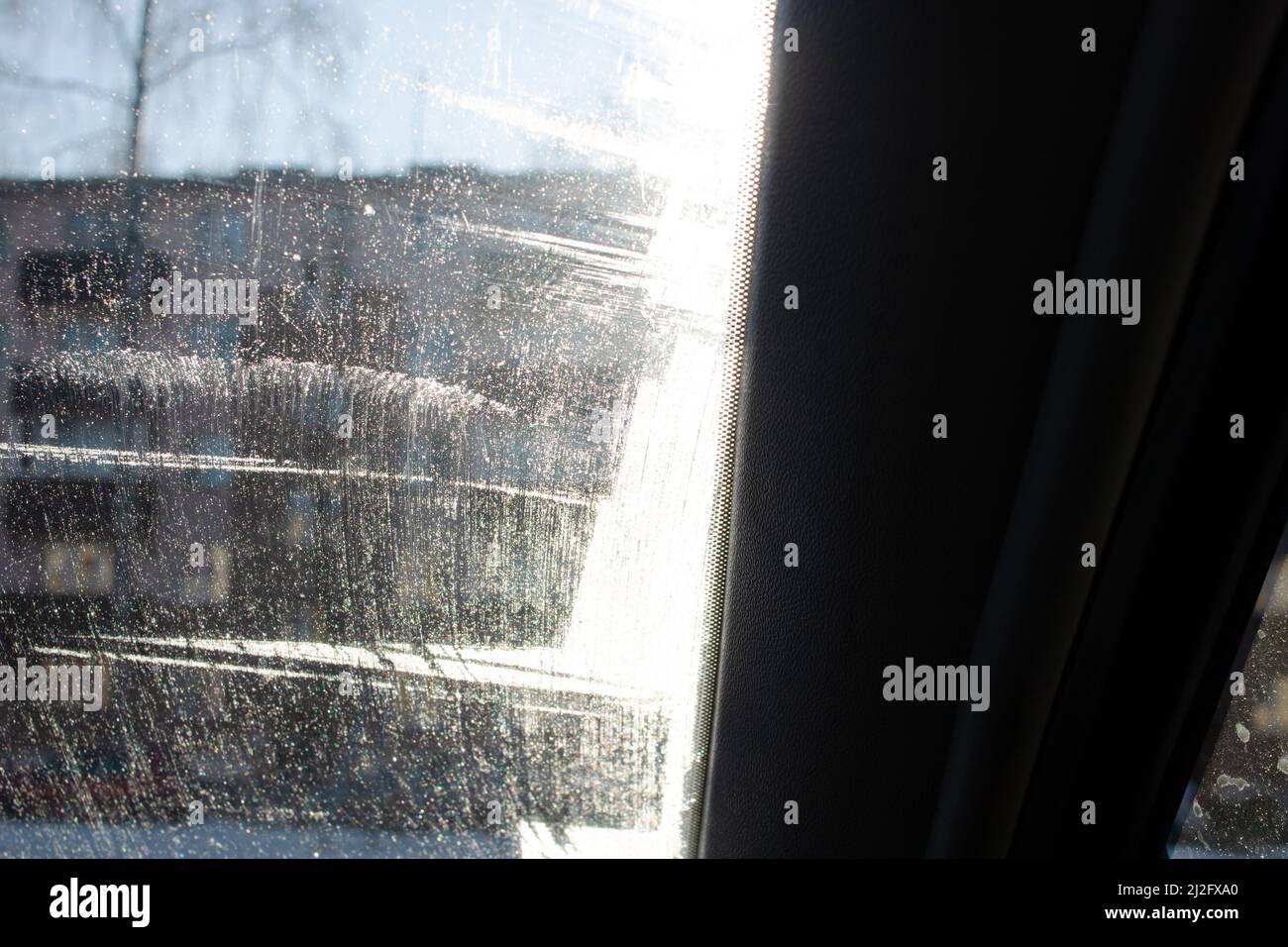 Modello di gelo su vetro dell'auto su sfondo cielo blu da vicino Foto Stock
