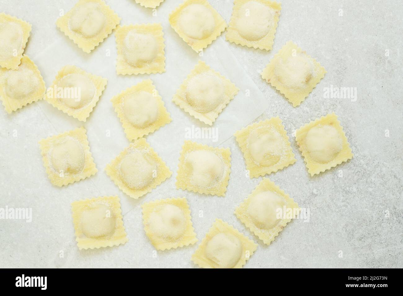 Ravioli crudi (gnocchi) disposti su sfondo grigio chiaro Foto Stock