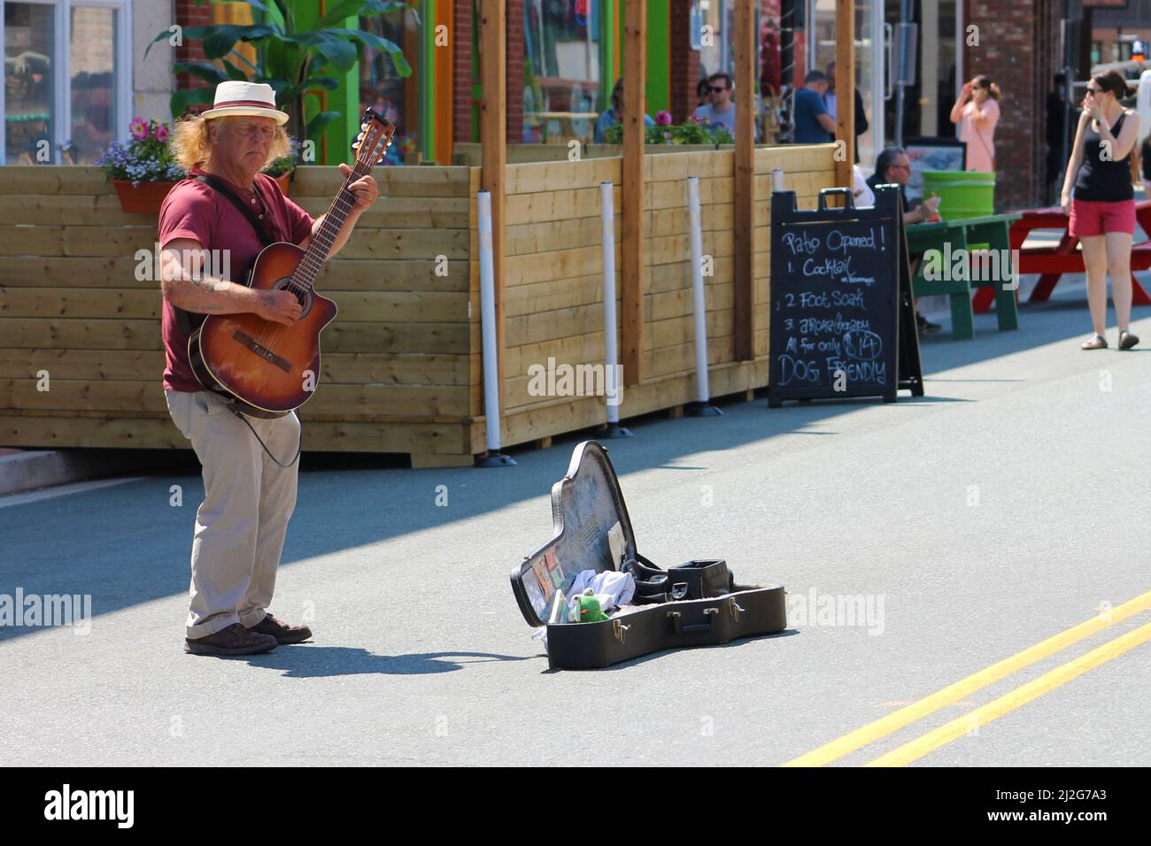 Un busker suona una chitarra su Water Street, St. John's, NL, Canada Foto Stock