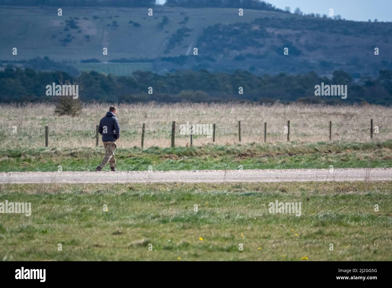 uomo che cammina a velocità lungo una strada non fatta, escursioni, fitness Foto Stock