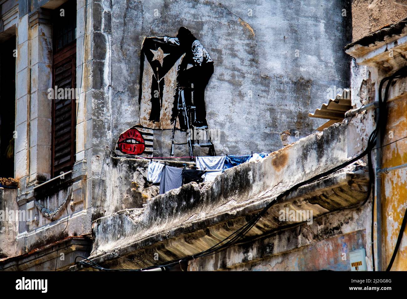 Interessante opera murale murale sul balcone di una casa a l'Avana, Cuba con una bandiera cubana in bianco e nero disegnato. Foto Stock