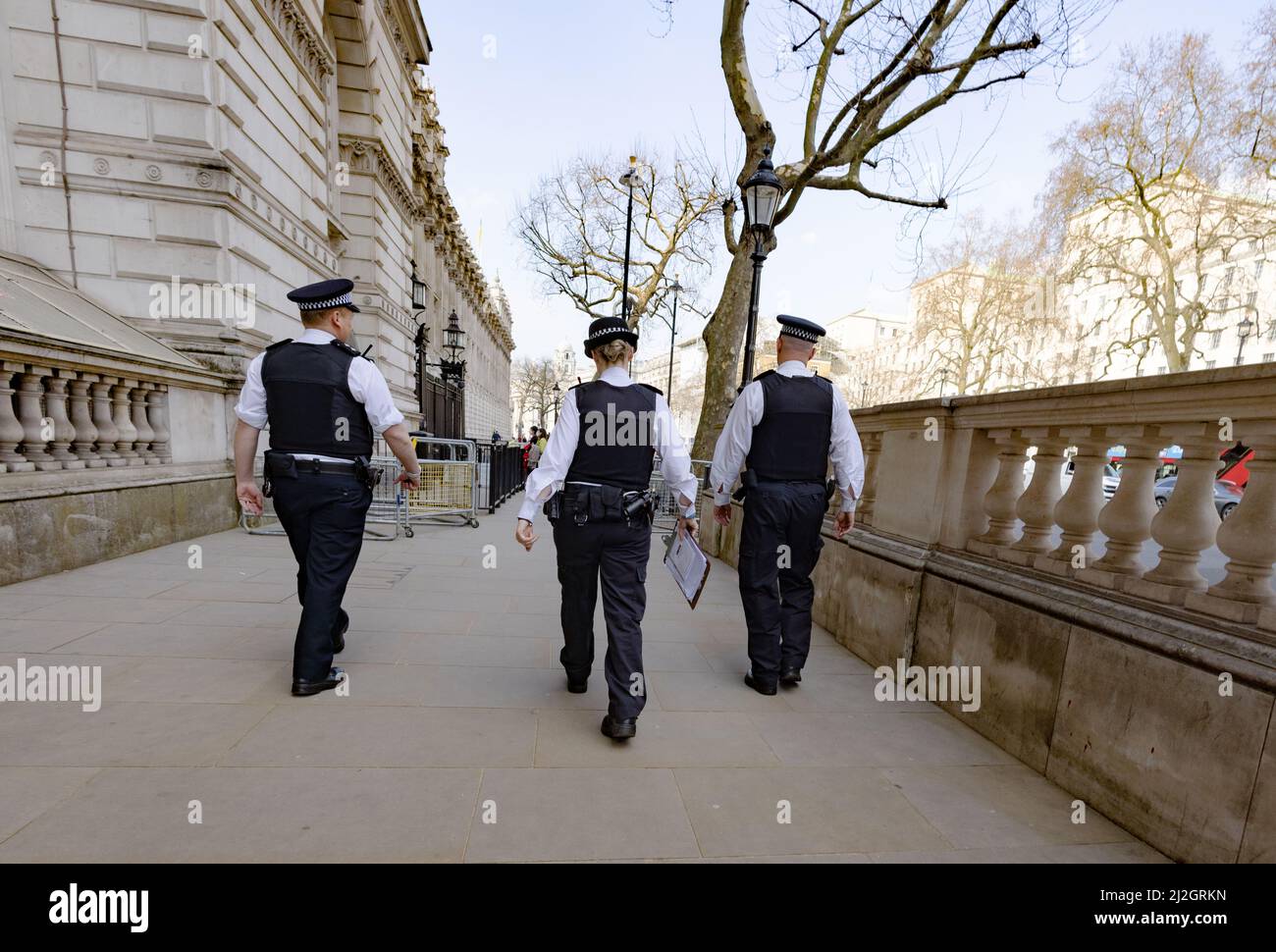 Metropolitan Police Force; tre poliziotti incontrati che camminano a Whitehall London SW1, vista posteriore, Central London UK Foto Stock