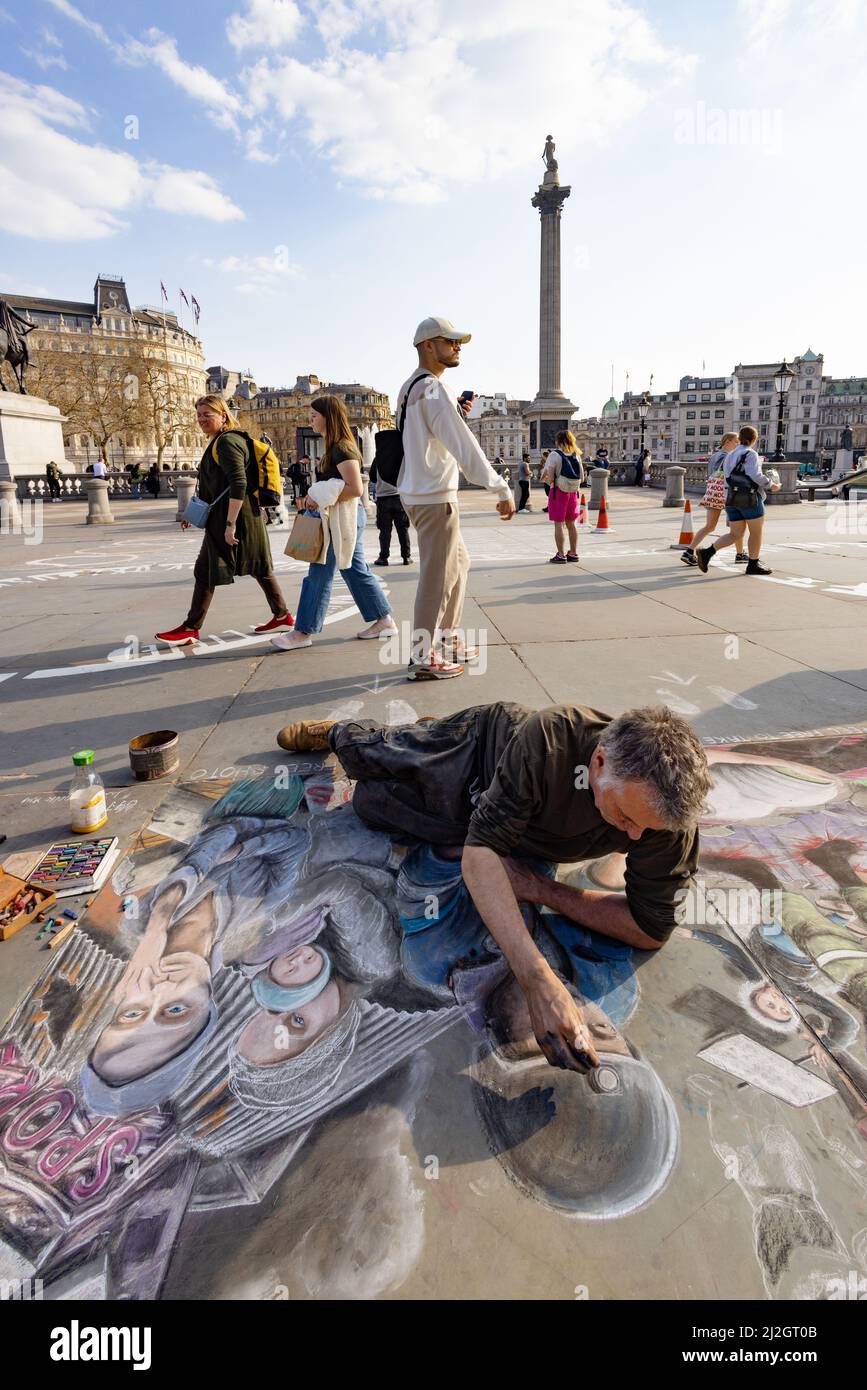 Artista di strada Trafalgar Square London UK; un artista di marciapiede che produce immagini di Street art in gesso, colonna Nelsons sullo sfondo, Londra Inghilterra Foto Stock