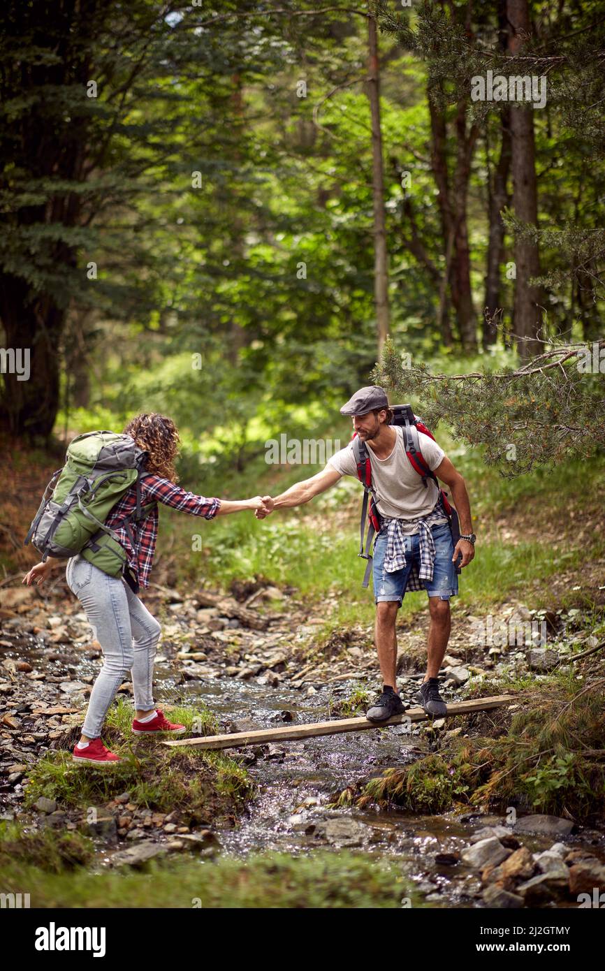 Giovani attraversando River.Journey nella foresta Foto Stock