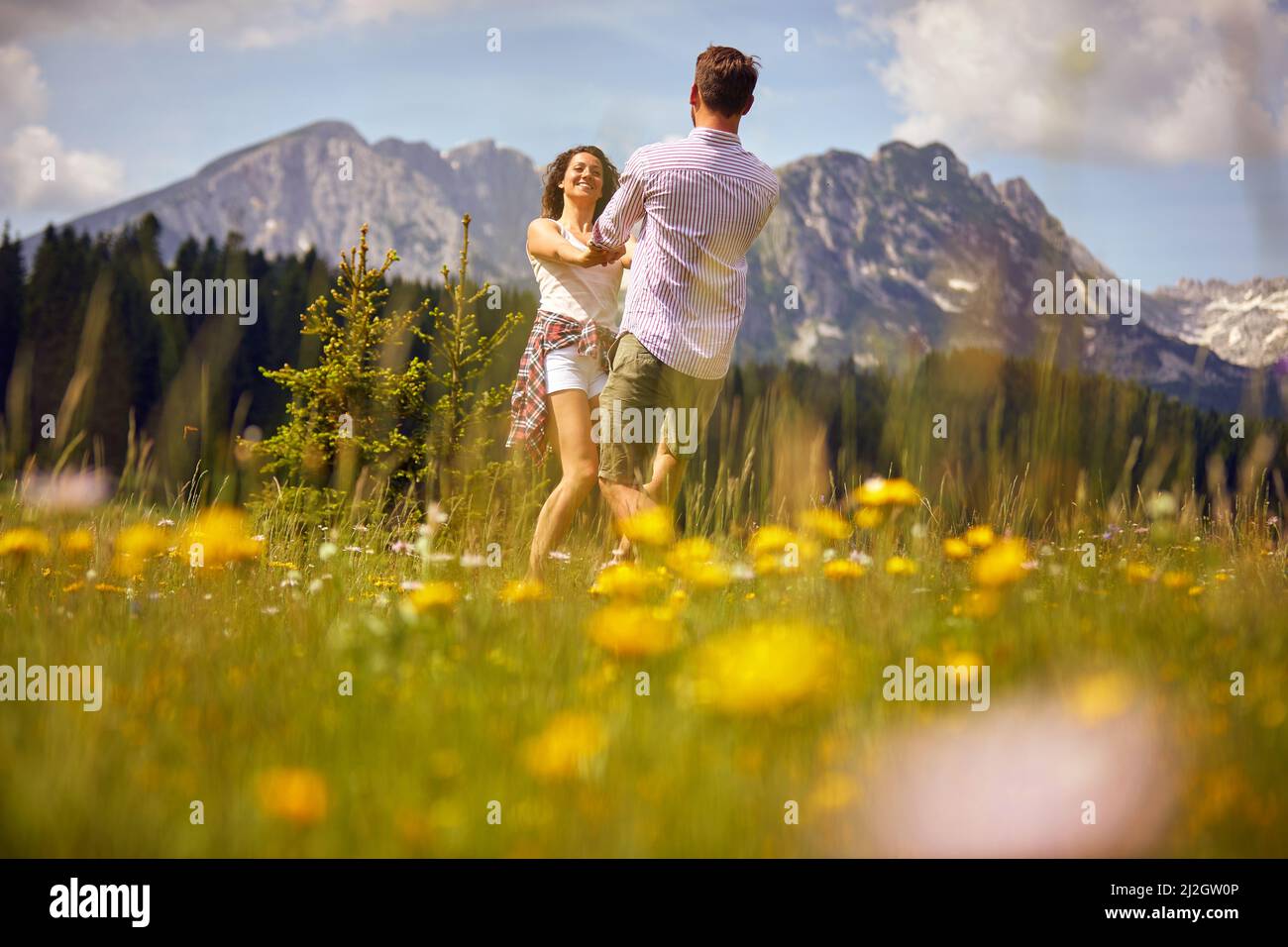 Coppia danzare in erba verde. Godersi il tempo nella natura. Divertimento, convivenza, concetto di natura. Foto Stock