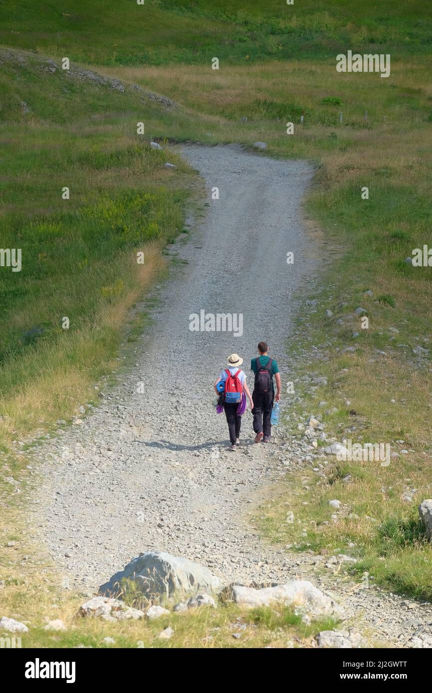 Giovane coppia di escursionisti con zaino che cammina su un sentiero sassoso, Montenegro Foto Stock