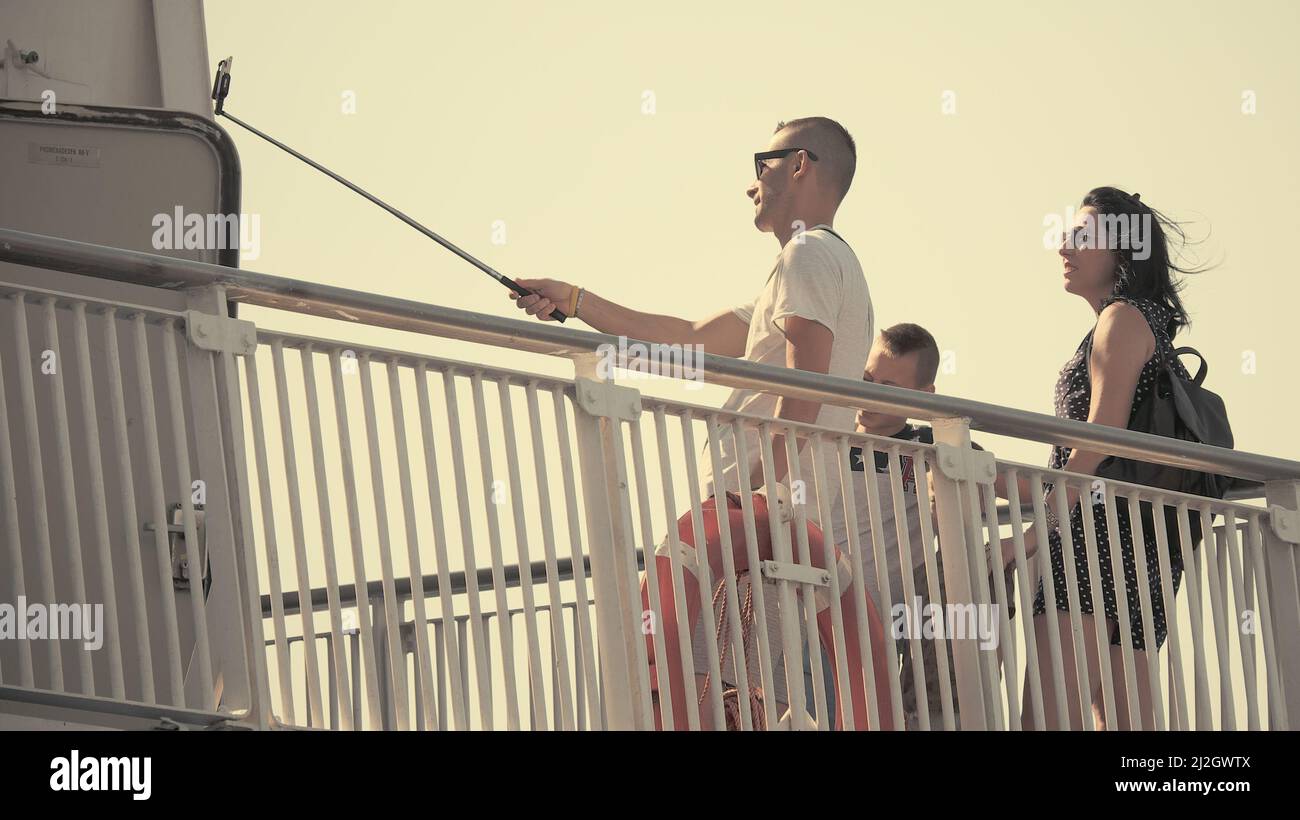 BARI, ITALIA - 17 LUGLIO 2017: Sulla nave traghetto famiglia non identificata che prende selfie utilizzando un palo per scattare una foto con smartphone Foto Stock