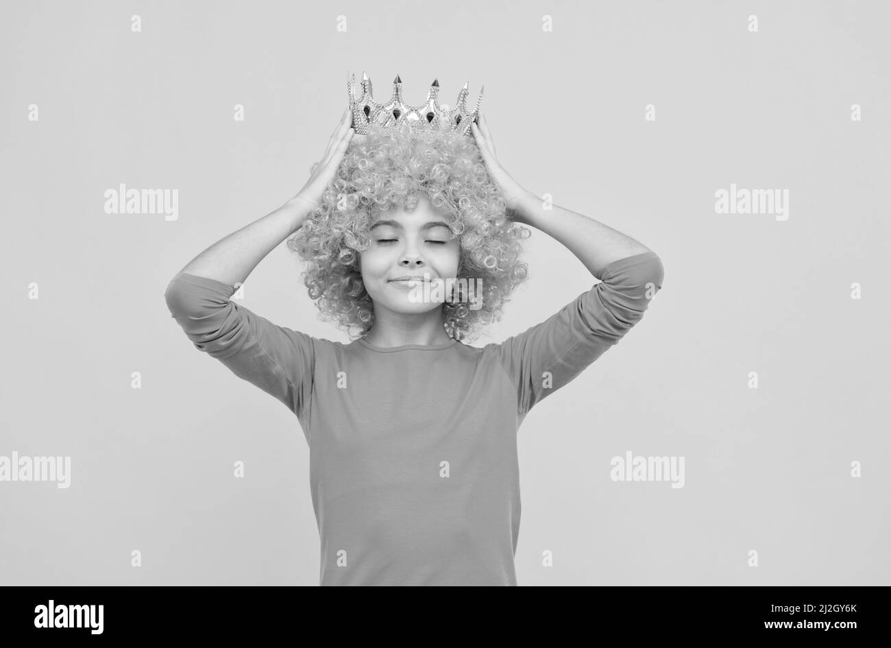ragazza teen soddisfatta in clown fantasia wig indossare corona regina, egoista Foto Stock