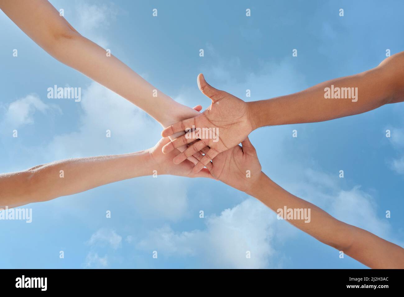 Possiamo realizzare tutto ciò a cui poniamo la nostra mente. Colpo di un gruppo di persone irriconoscibili che si accatastano le mani. Foto Stock