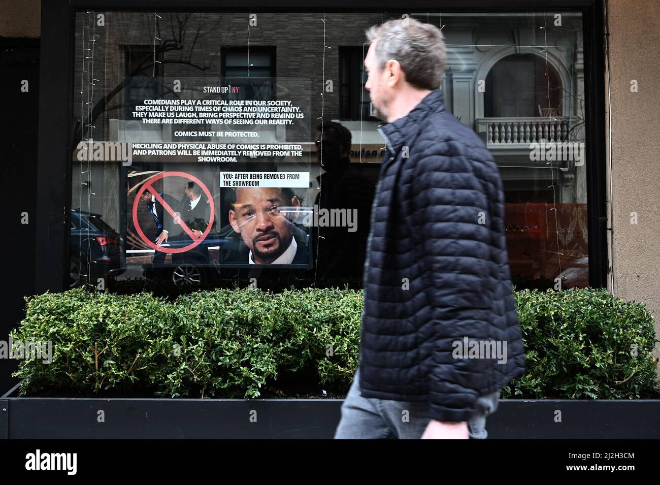 New York, Stati Uniti. 01st Apr 2022. Un uomo guarda un poster impostato nella finestra del New York Comedy Club Stand Up NY, avverte i patroni che qualsiasi heckling o violenza fisica contro comics performance non sarà tollerato, New York, NY, 1 aprile 2022. L'avvertimento è in reazione all'attore Will Smith che schiaffa il comico Chris Rock durante gli Academy Awards del 94th il 27 marzo, reagendo allo scherzo presentato da MR. Rock per quanto riguarda la testa rasata della moglie di MR. Smith, che soffre di alopecia. (Foto di Anthony Behar/Sipa USA) Credit: Sipa USA/Alamy Live News Foto Stock