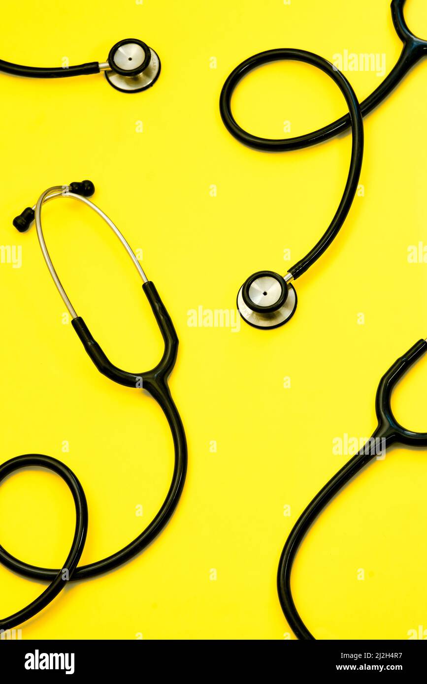 Ascoltate il vostro cuore. Studio di stetoscopi su sfondo giallo chiaro. Foto Stock