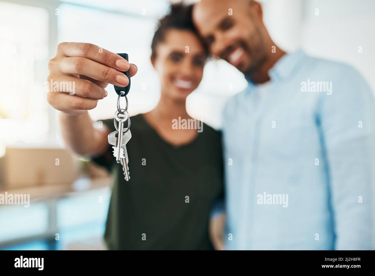 Fate un passo avanti verso un nuovo inizio. Ritratto di una giovane coppia che tiene le chiavi della loro nuova casa. Foto Stock