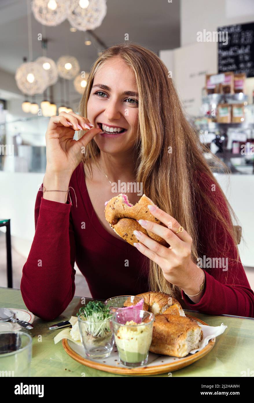 Donna sorridente che fa colazione al ristorante Foto Stock