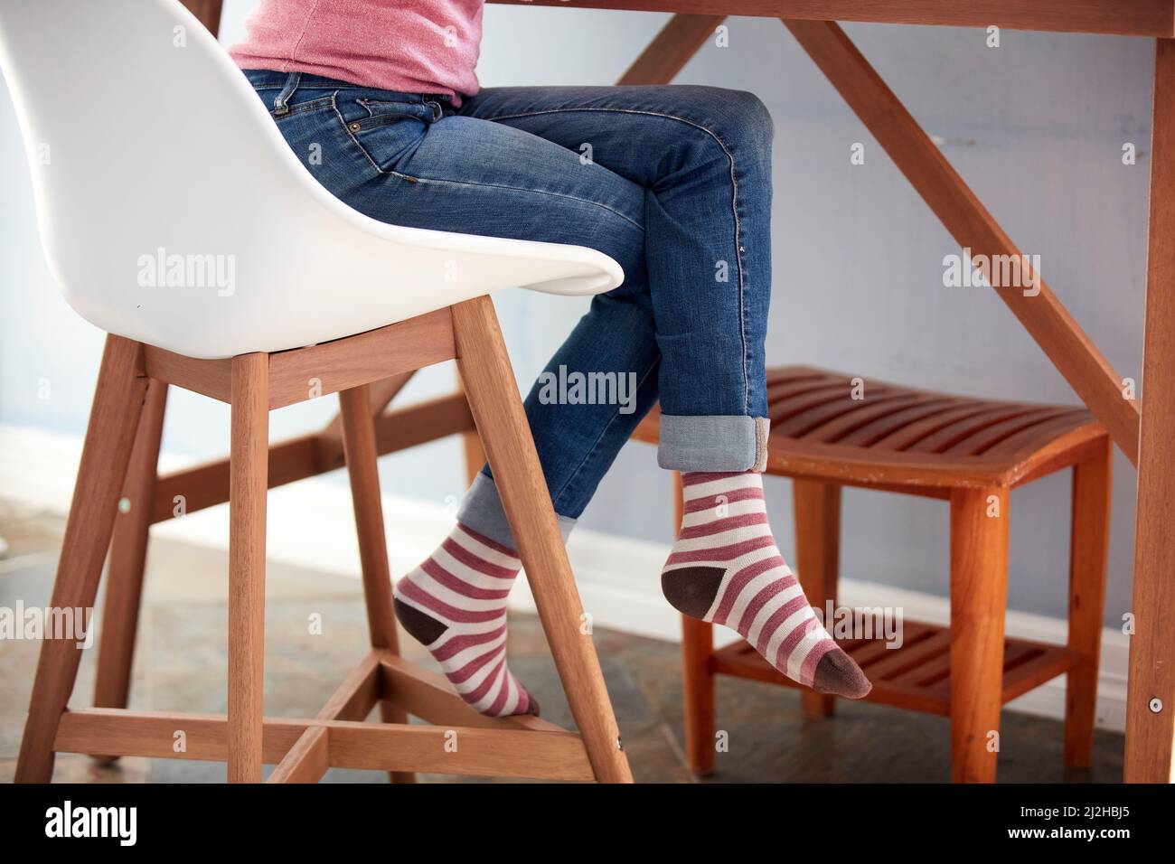 Gambe femminili in jeans e calzini a righe Foto Stock