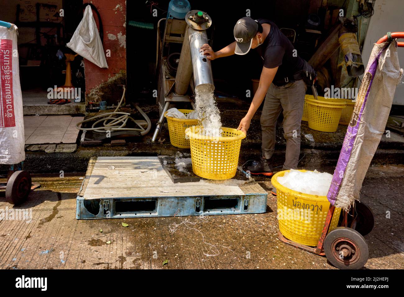 Produzione di ghiaccio. Operatore che fa ghiaccio tritato per la conservazione locale del cibo del mercato del pesce. Thailandia, S. E. Asia Foto Stock