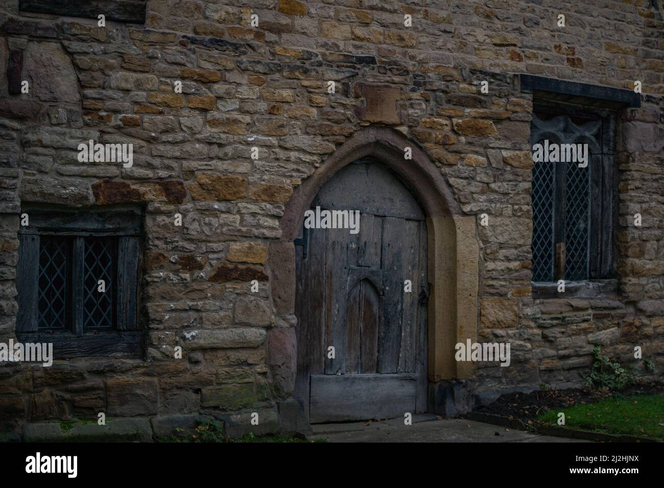 Arco in pietra medievale / porta con porta storta e originale / presentano finestre fatte a mano. Foto Stock