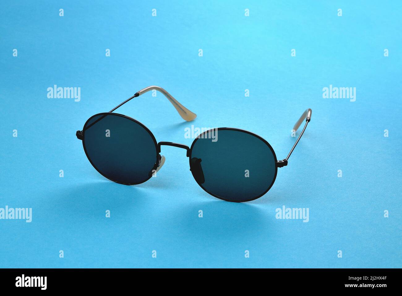 Occhiali da sole, eleganti occhiali da sole su sfondo blu, messa a fuoco selettiva ravvicinata Foto Stock