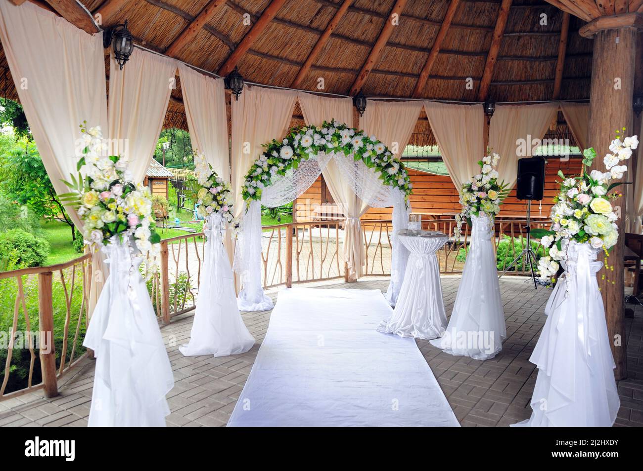 Decorazione floreale dell'arco di nozze, arco di rose bianche da vicino con il verde, cerimonia nuziale di campagna, matrimonio rustico all'aperto Foto Stock
