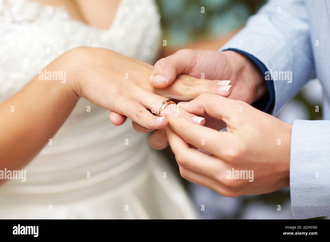 Scambio di anelli di cerimonia nuziale. Cerimonia nuziale. Lo sposo mette su anello dorato di cerimonia nuziale al dito del bridal, primo piano. Sposi e sposi, sposi novelli. Foto Stock