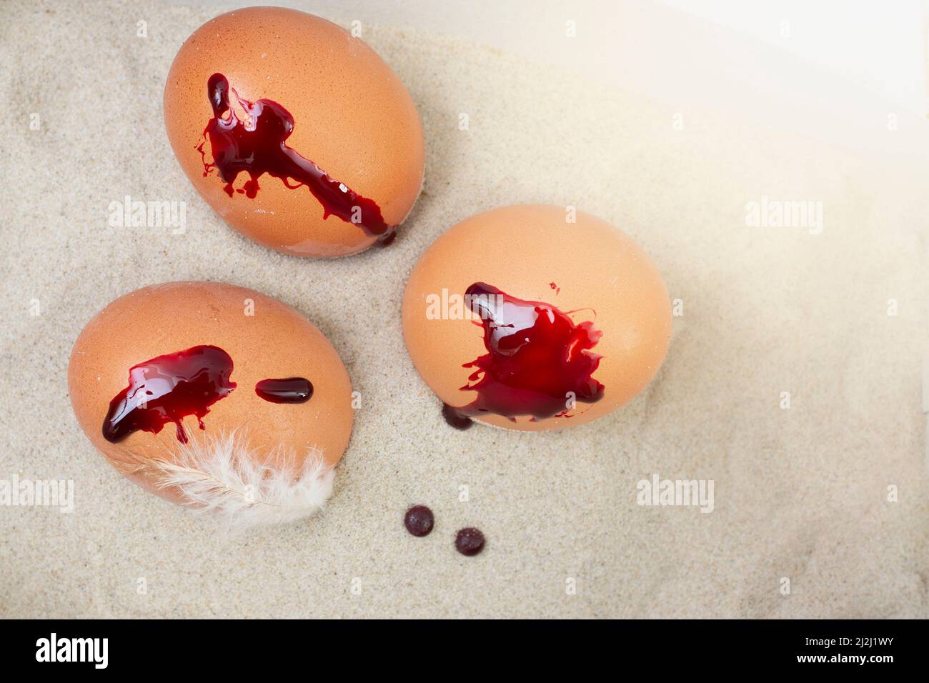 gocce di sangue sulle uova di pasqua, e sabbia Foto Stock