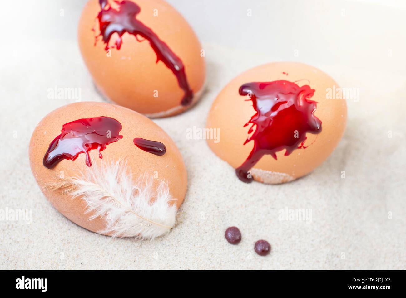 gocce di sangue sulle uova di pasqua, e sabbia Foto Stock