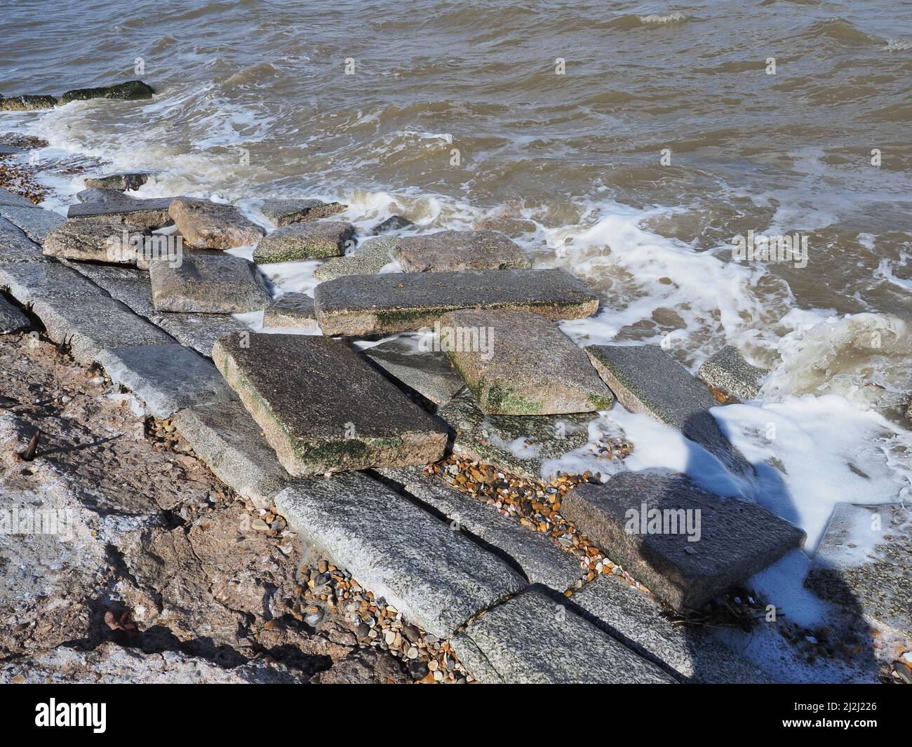 Sheerness, Kent, Regno Unito. 2nd Apr 2022. UK Meteo: Le difese del mare a Sheerness, Kent sono state danneggiate / compromesse da tempo cattivo recente, tra cui diversi giorni di forti venti del nord est e una marea di picco ieri. Un enorme buco è apparso nelle difese del mare dove molti grandi flagstones sono caduti dalla fascia protettiva del mare. Credit: James Bell/Alamy Live News Foto Stock