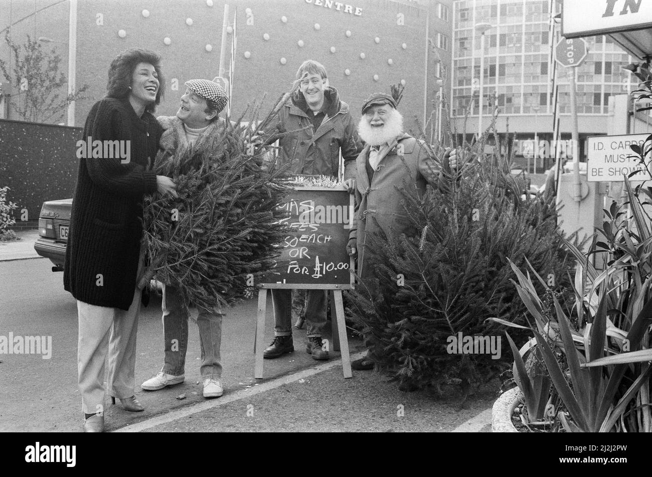 Da sinistra a destra, David Jason come del Boy, Nicholas Lyndhurst come Rodney e Buster Merryfield come zio Albert da 'Only Fools and Horses' con alberi di Natale fuori dal BBC Television Center. Raffigurato con Moira Stuart. 7th dicembre 1987. Foto Stock