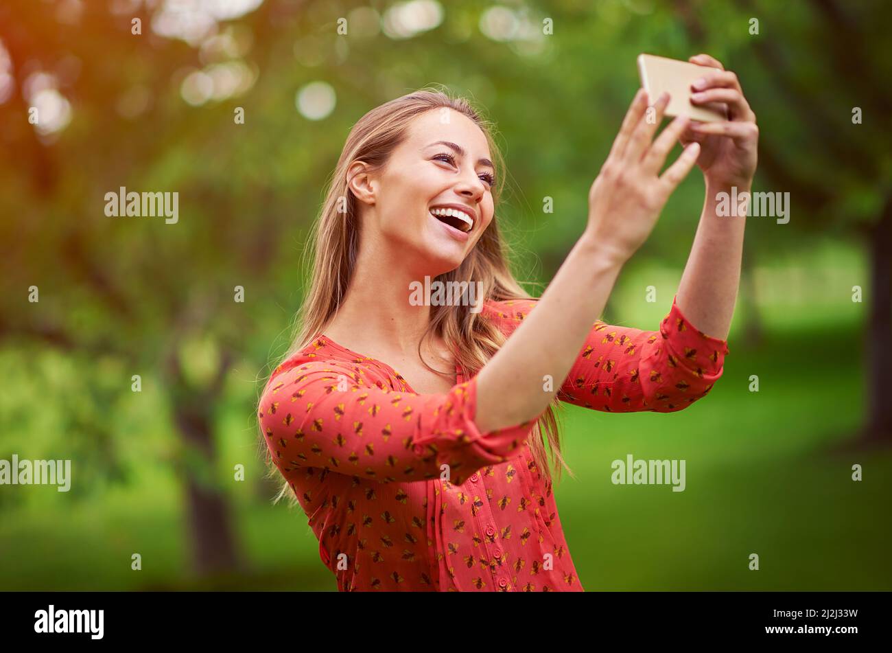 Questo farà un grande profilo pic. Scatto di una giovane donna che prende un selfie fuori. Foto Stock