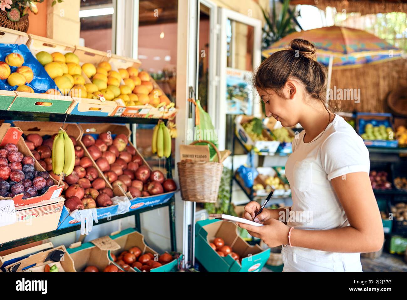 Fare il punto. Scatto corto di una giovane donna attraente che lavora ad una bancarella di fattoria. Foto Stock