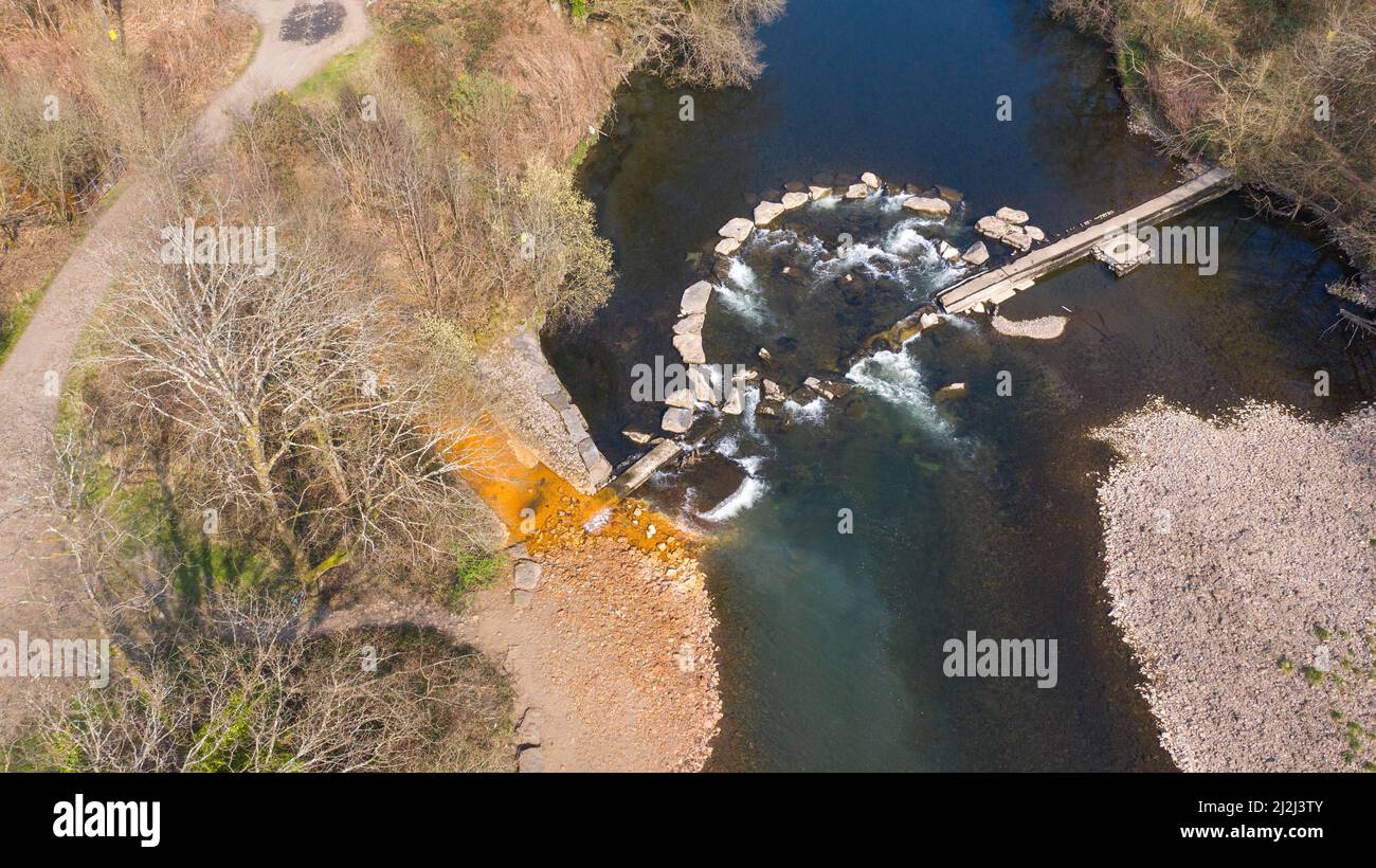 Vista aerea della colorazione arancione ossido di ferro in corrente che entra nel fiume Neath ad Abergarwed. La fonte è lo scarico di acqua da una miniera di carbone abbandonata. Foto Stock