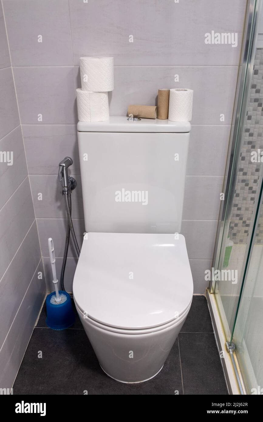 Ciotola bianca con rotoli di carta igienica sulla parte superiore. Foto Stock