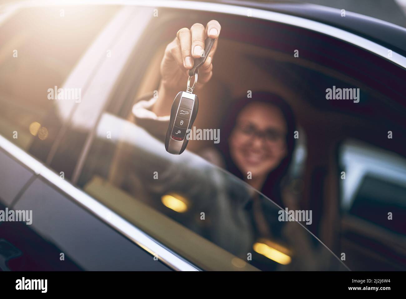 Indovinate chi ha appena comprato delle nuove ruote. Ritratto di una donna d'affari che tiene le chiavi della sua nuova auto. Foto Stock