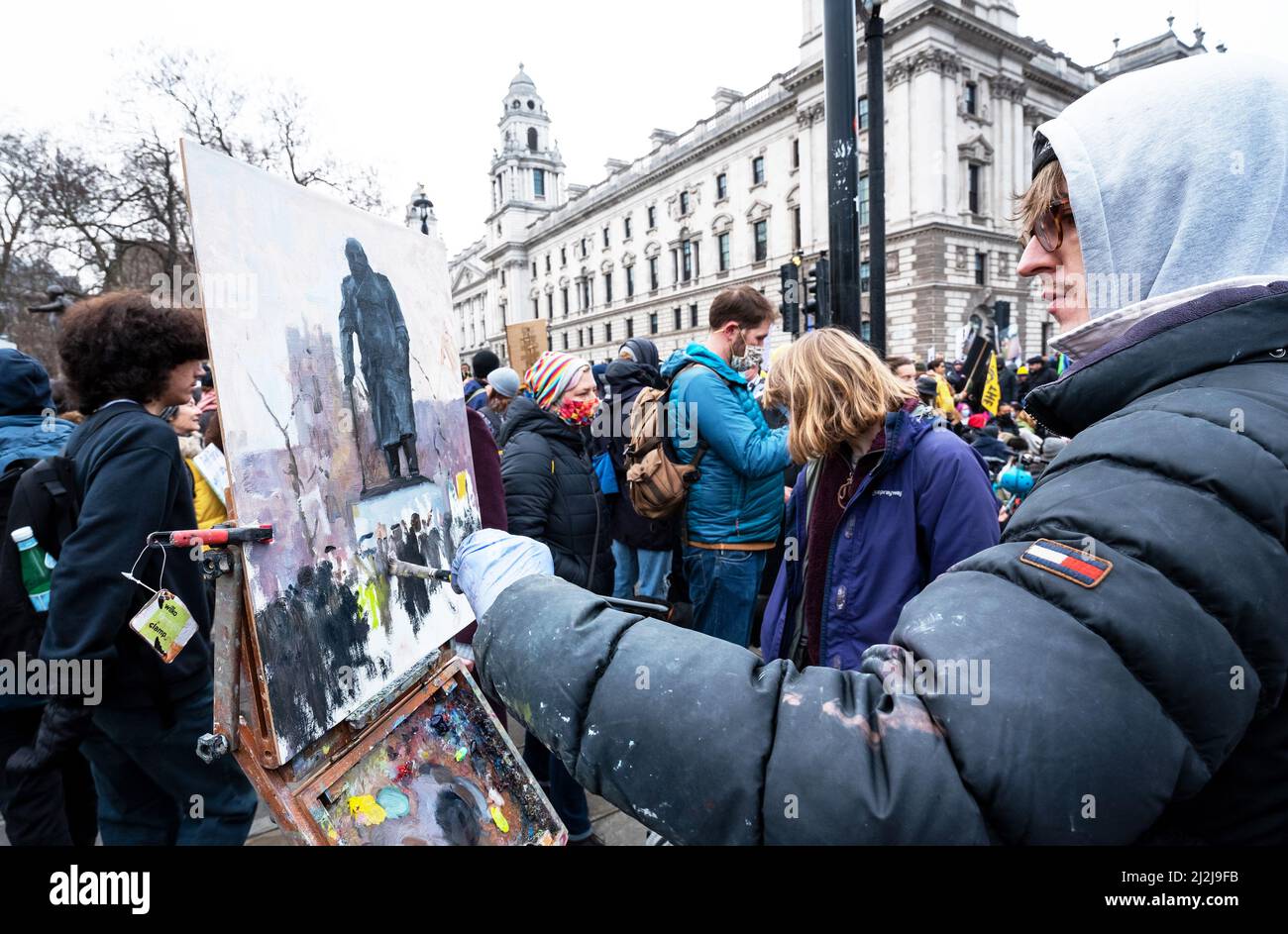 Artista pittura con oli la statua di Sir Winston Churchill nella Piazza del Parlamento di Londra. Il dipinto si stava avvicinando al completamento come una marcia di migliaia di uccidere i manifestanti di legge sono arrivati in piazza per un rally. Credito: Stephen Bell/Alamy Foto Stock