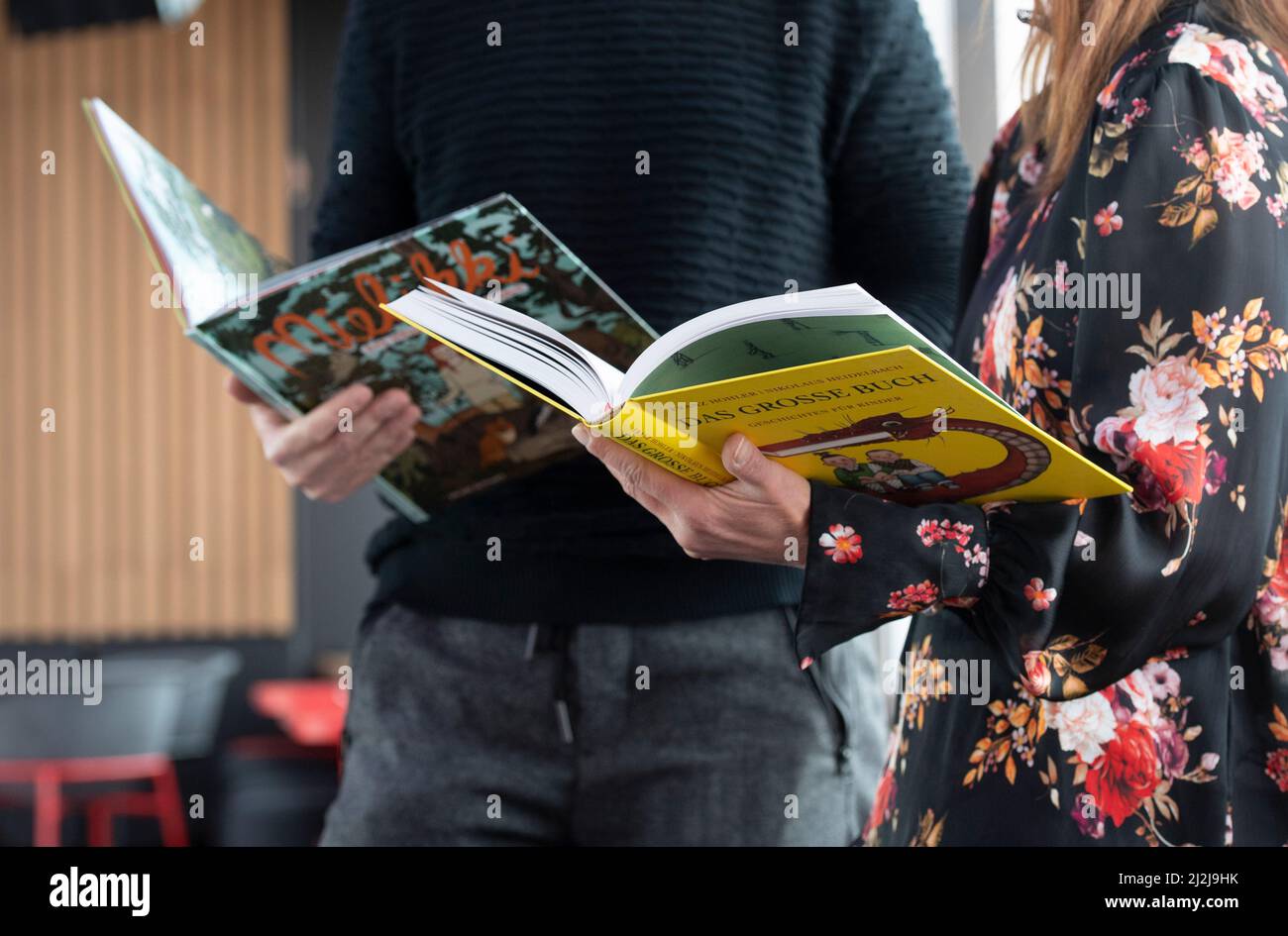 Berlino, Germania. 02nd Apr 2022. Una donna e un uomo tengono in mano i libri dei bambini prima dell'inizio della lettura ad alta voce del record mondiale di LeseLounge e.V.. La maratona a lettura ad alta voce si svolge presso la sede del rbb Rundfunk Berlino-Brandeburgo. Credit: Paul Zinken/dpa/Alamy Live News Foto Stock