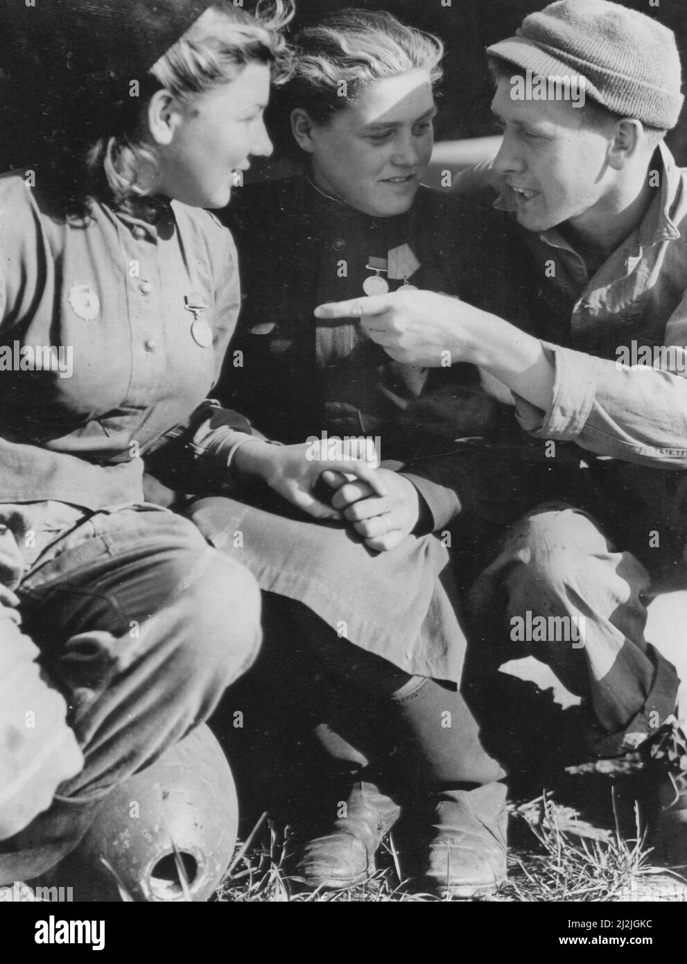 In una delle nuove basi aeree statunitensi in Russia, Sgt. G.S. McCall, 926 Telegair St., Augusta, GA., esamina le medaglie di due donne russe soldati, entrambi 21 anni. Entrambe le donne sono veterane delle battaglie di Leningrado e Stalingrado Foto Stock