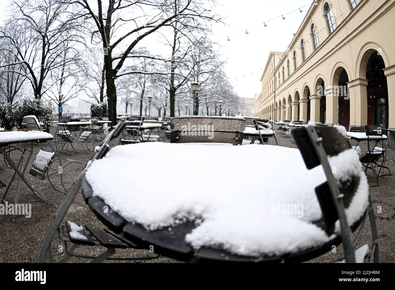 Monaco di Baviera, Germania. 02nd Apr 2022. I tavoli sono coperti di neve nel Hofgarten. Ha nevicato a Monaco. Credit: Felix Hörhager/dpa/Alamy Live News Foto Stock