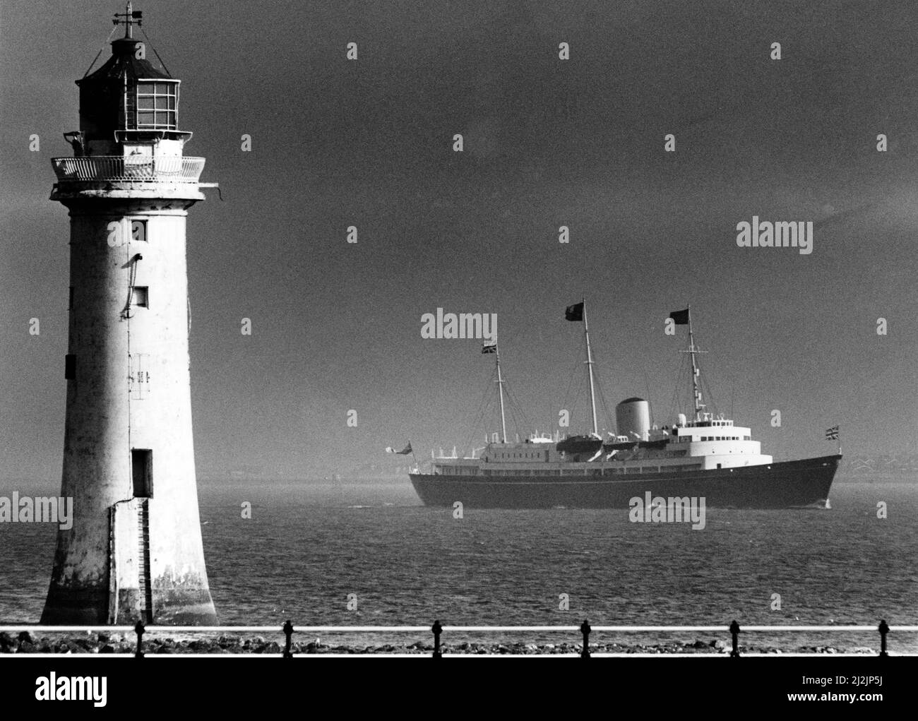 La Regina Elisabetta II visita Liverpool, Merseyside. L'HMS Brittania si fa strada maestosa davanti al faro di Perch Rock, sulla Mersey. Data della foto 8th agosto 1988 Foto Stock