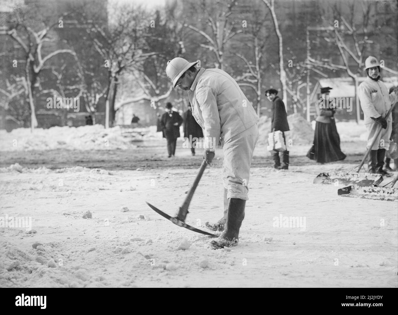 Man clearing Street with pickaxe after snow storm, New York City, New York, USA, Bain News Service, 1908 Foto Stock