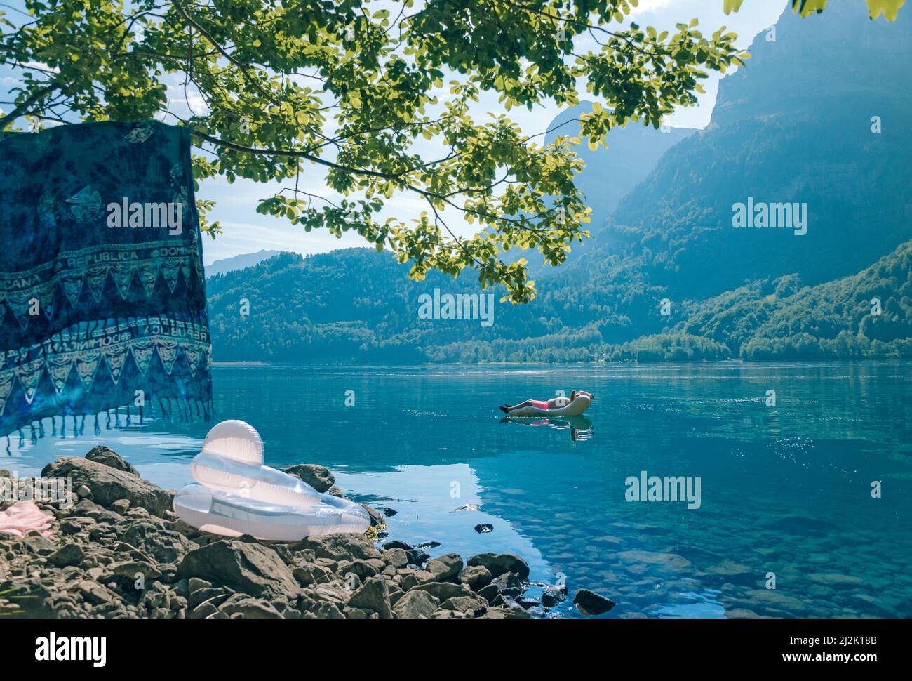 Uomo che galleggia su un lilo, Lago Klontal, Glarona, Svizzera Foto Stock